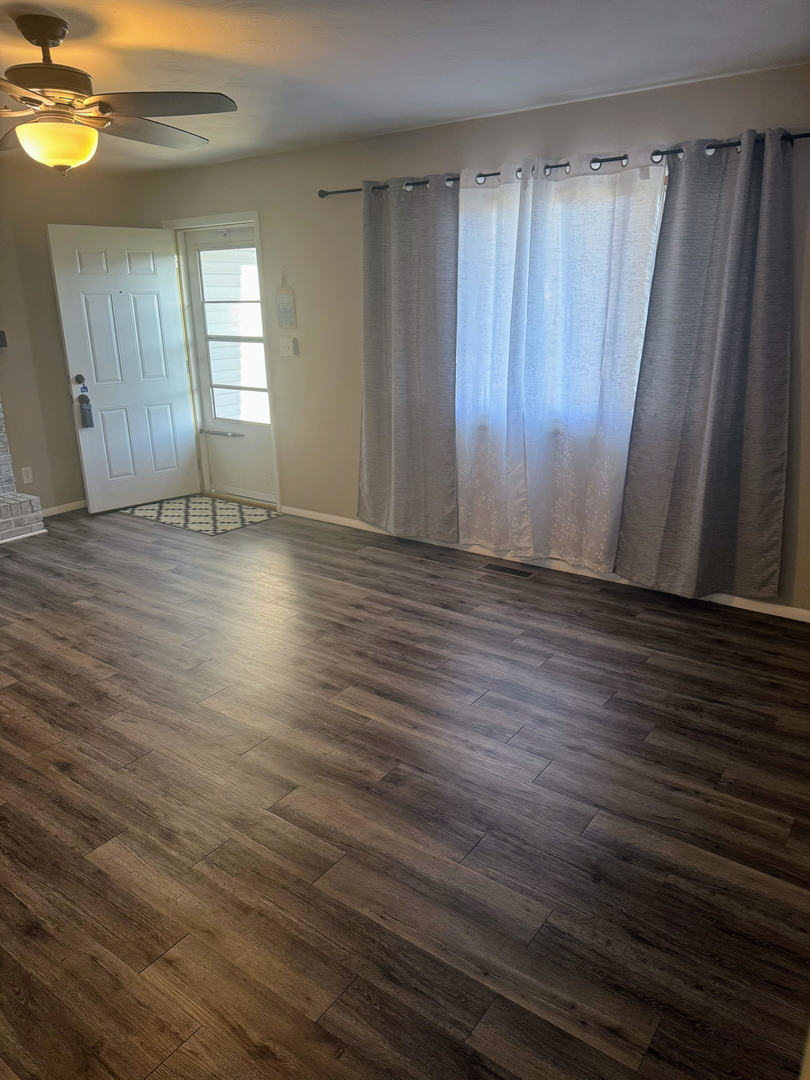 2511 Trafalgar Square Champaign, IL 61821 - Photo 8 of 26 an empty room with wooden floor and windows with curtains