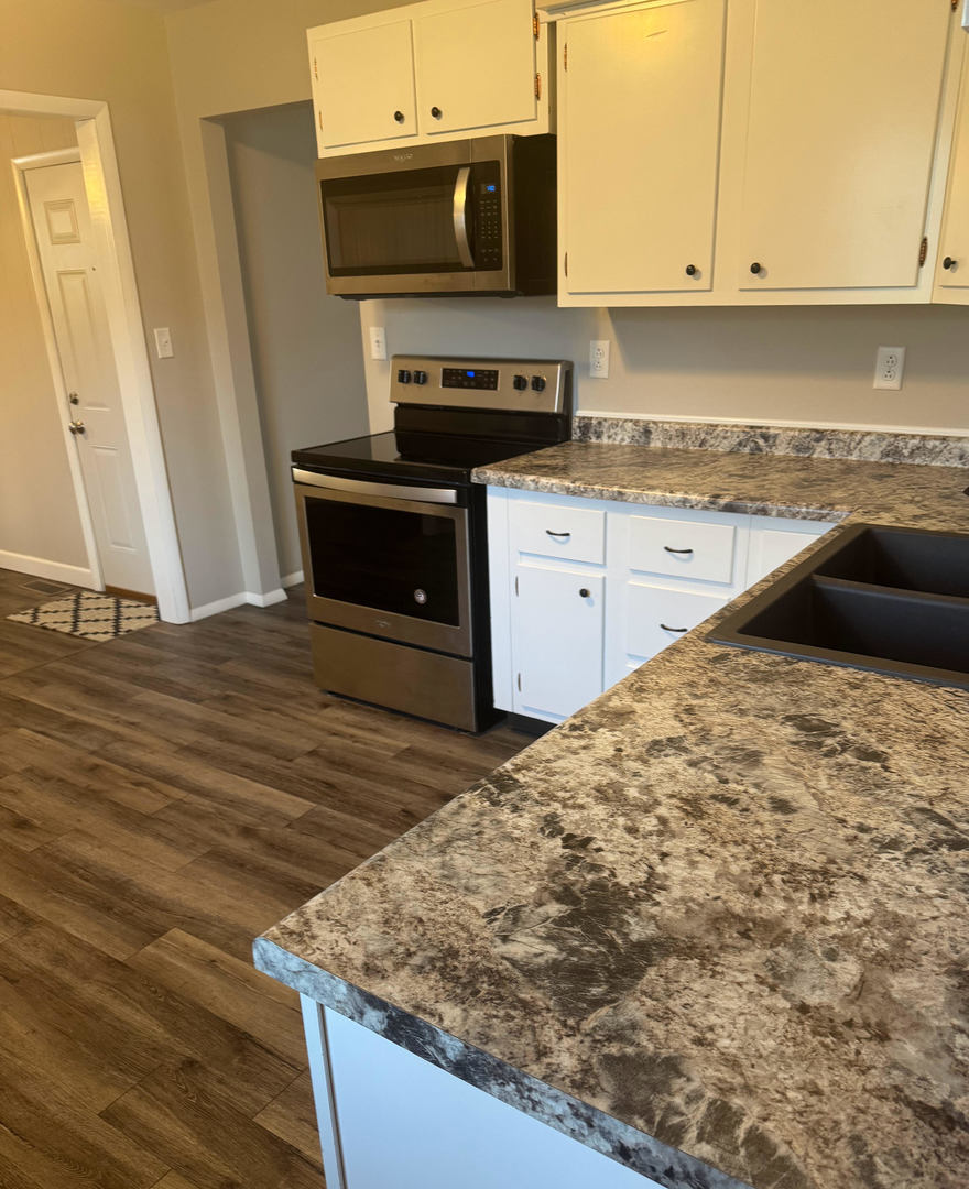 2511 Trafalgar Square Champaign, IL 61821 - Photo 9 of 26 a kitchen with granite countertop a sink and a stove top oven
