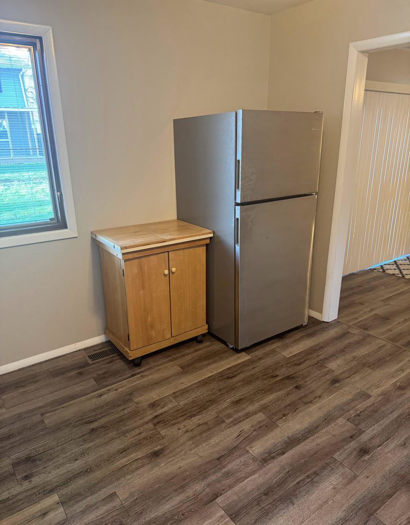 2511 Trafalgar Square Champaign, IL 61821 - Photo 10 of 26 a view of a refrigerator in kitchen and an empty room with wooden floor