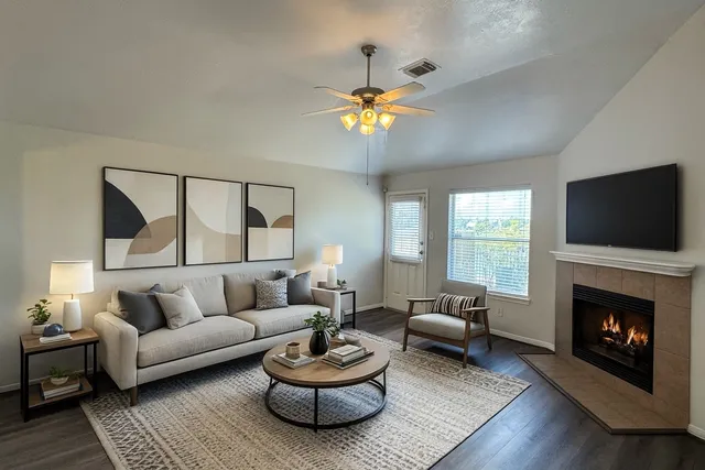 a living room with furniture a fireplace and a flat screen tv