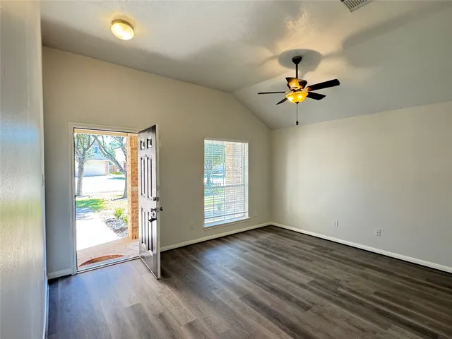 a view of empty room with wooden floor and fireplace