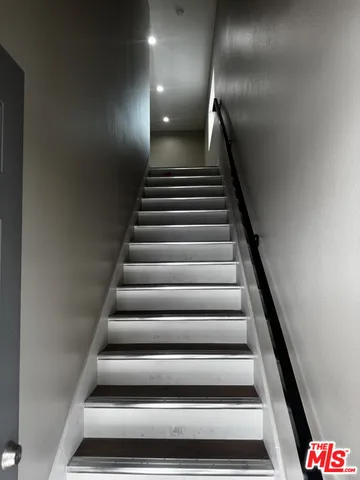 an empty room with wooden floor and staircase