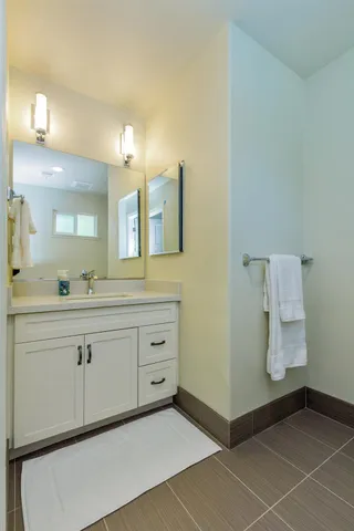 a view of an empty room with wooden floor and a ceiling fan