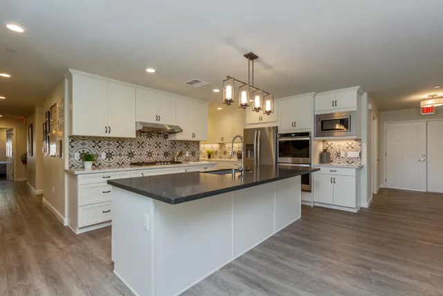 a kitchen with stainless steel appliances kitchen island granite countertop a large counter top and stainless steel appliances
