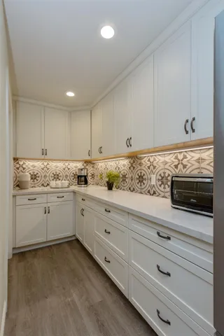 a kitchen with granite countertop white cabinets white stainless steel appliances and sink