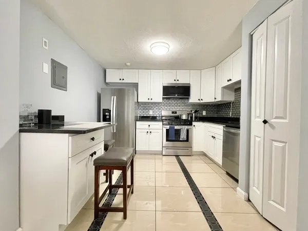 a kitchen with stainless steel appliances a refrigerator sink and white cabinets