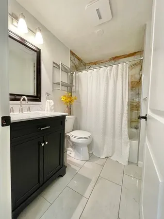 a bathroom with a double vanity sink toilet and mirror
