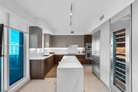 a kitchen with a sink a counter top space stainless steel appliances and cabinets