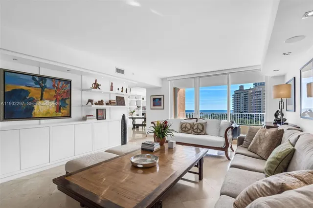 a living room with furniture kitchen view and a window
