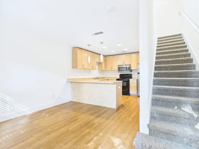 a view of kitchen with wooden floor and electronic appliances