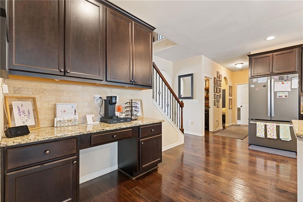 2352 Alexander Top Place Grayson, GA 30017 - Photo 17 of 66 a kitchen with stainless steel appliances granite countertop a refrigerator a sink dishwasher and wooden cabinets with wooden floor