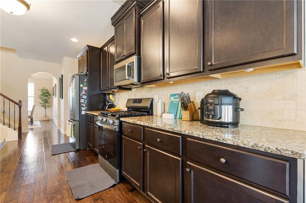 2352 Alexander Top Place Grayson, GA 30017 - Photo 23 of 66 a kitchen with stainless steel appliances granite countertop a refrigerator a sink dishwasher a stove and white countertops with wooden floor