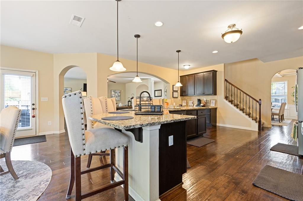 2352 Alexander Top Place Grayson, GA 30017 - Photo 24 of 66 a kitchen with stainless steel appliances kitchen island a table chairs in it and wooden floors