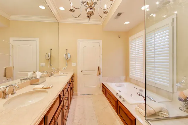a bathroom with a double vanity sink mirror and bathtub