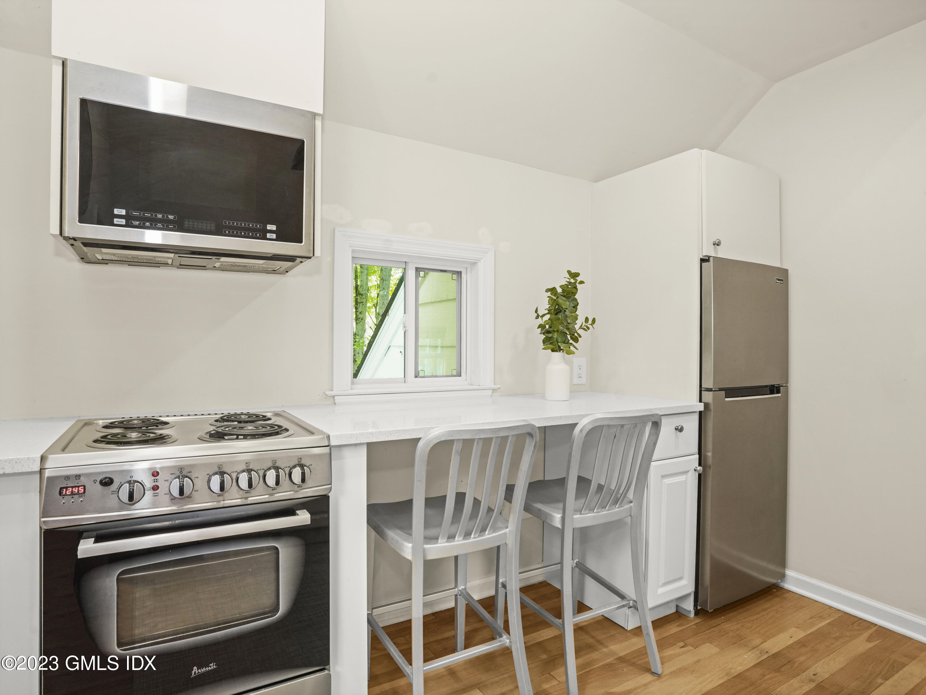 470 June Road, Unit STUDIO Stamford, CT 06903 - Photo 5 of 11 a kitchen with a stove and a microwave