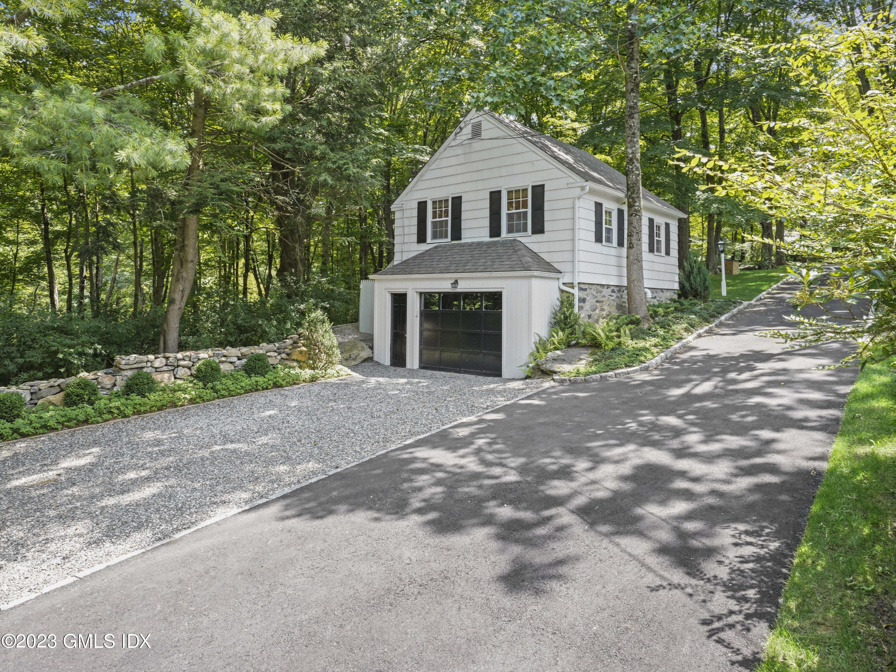 470 June Road, Unit STUDIO Stamford, CT 06903 - Photo 7 of 11 a front view of a house with a yard and trees
