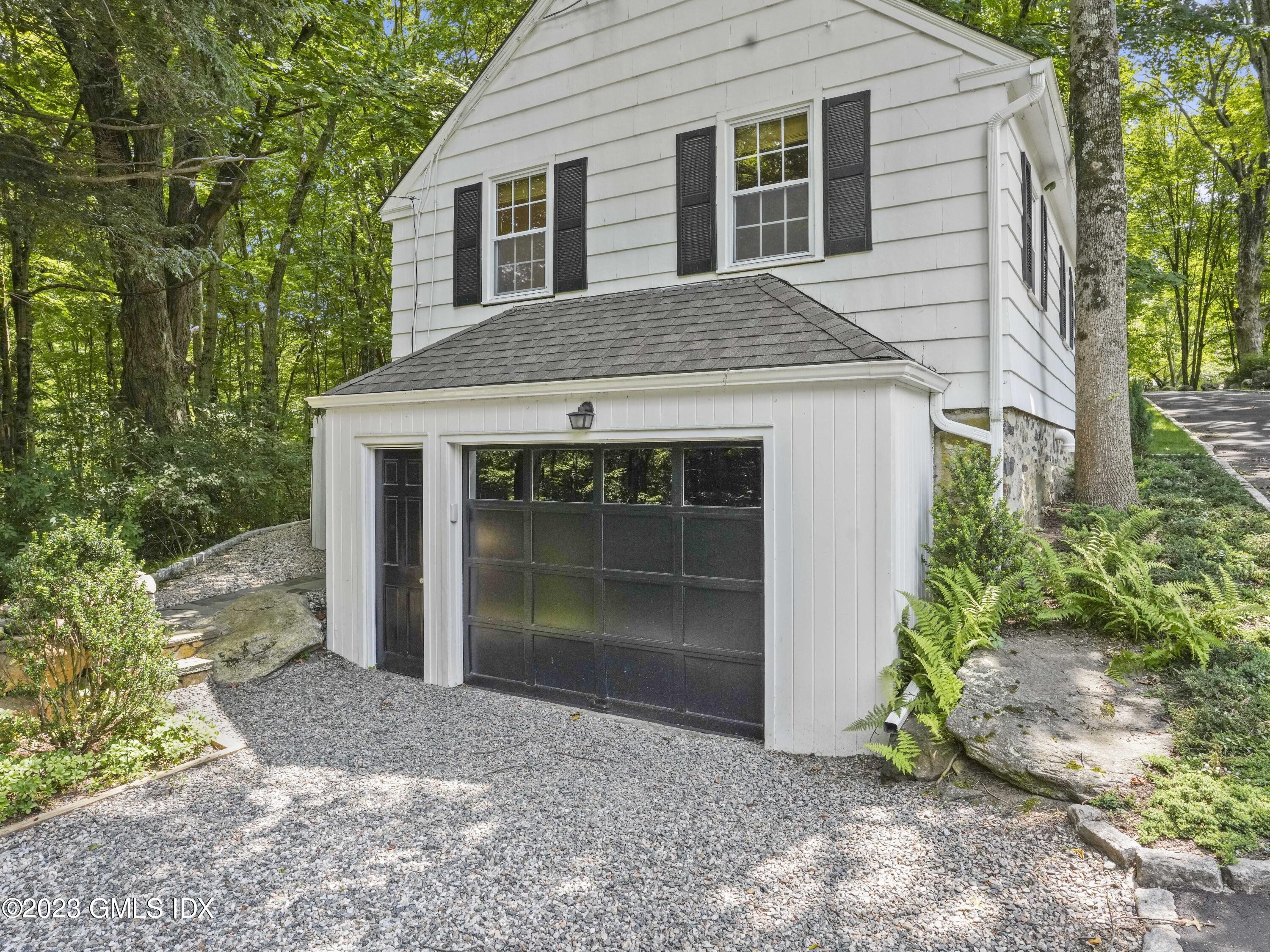 470 June Road, Unit STUDIO Stamford, CT 06903 - Photo 9 of 11 a front view of a house with a garden and yard