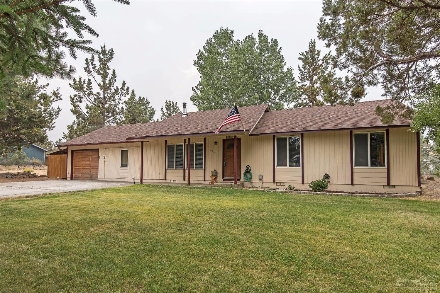 a front view of a house with a yard and trees