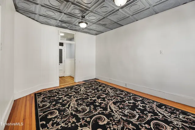 a view of an empty room with cabinet and a refrigerator