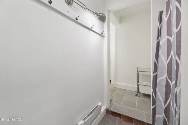 a view of a hallway with wooden floor and furniture