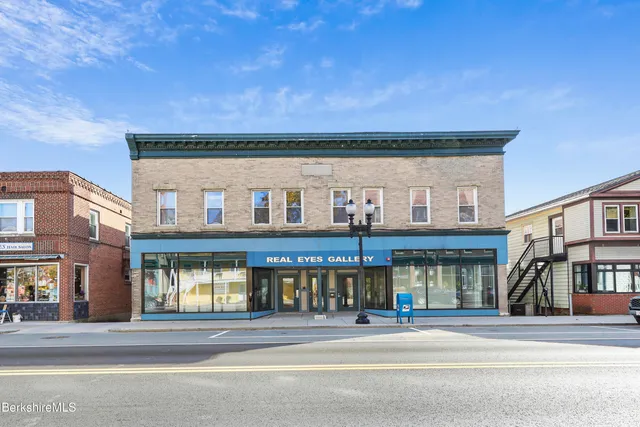 a view of a hallway with wooden floor and closet
