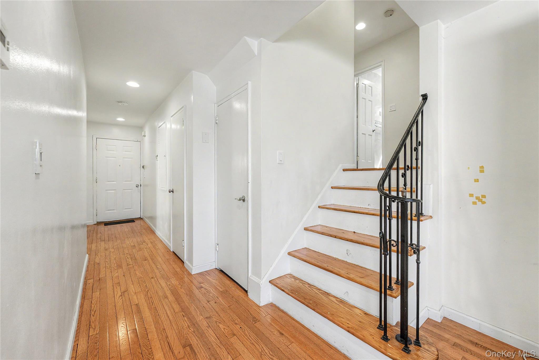 567 Oxford Road Cedarhurst, NY 11516 - Photo 11 of 31 a view of a hallway with wooden floor and staircase