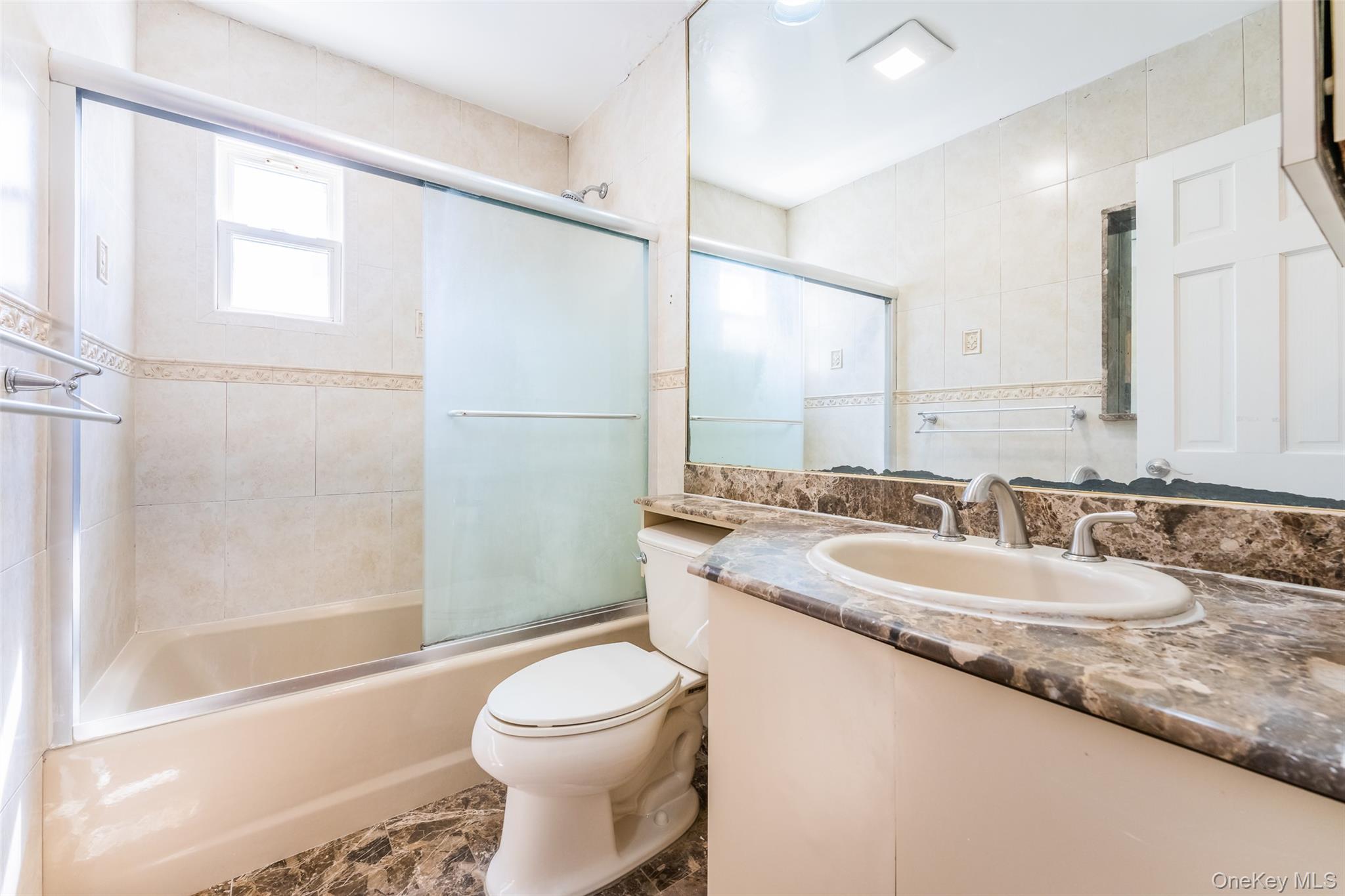 567 Oxford Road Cedarhurst, NY 11516 - Photo 13 of 31 a bathroom with a granite countertop sink a toilet a mirror and shower