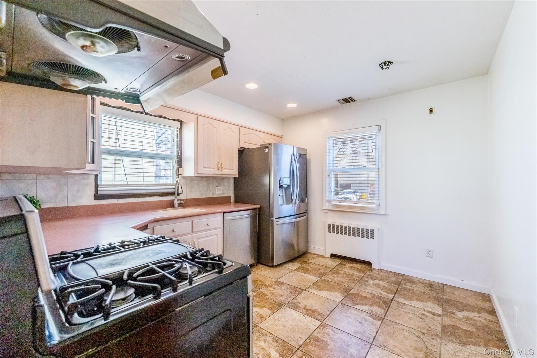 567 Oxford Road Cedarhurst, NY 11516 - Photo 3 of 31 a kitchen with stainless steel appliances granite countertop a stove and a refrigerator