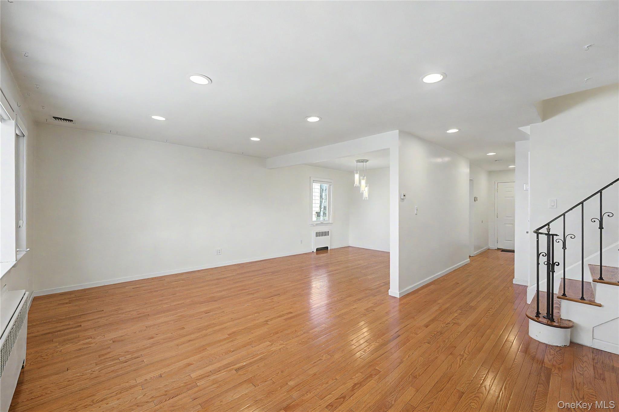 567 Oxford Road Cedarhurst, NY 11516 - Photo 10 of 31 a view of an empty room with wooden floor and a window