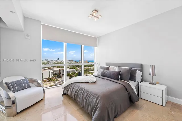 a bedroom with a bed couch and a large window