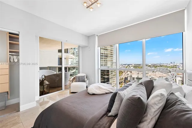 a bedroom with furniture and a large window