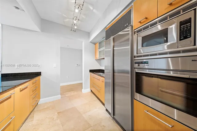 a kitchen with stainless steel appliances granite countertop a refrigerator and a stove top oven