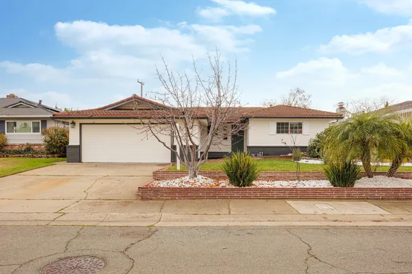 a front view of a house with a garden and patio