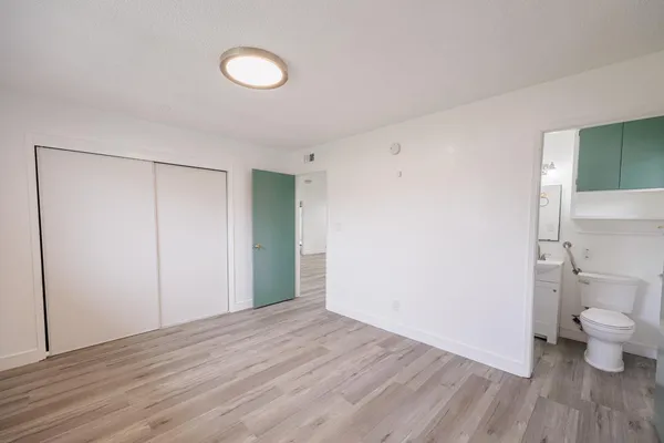 a view of a room with wooden floor and toilet