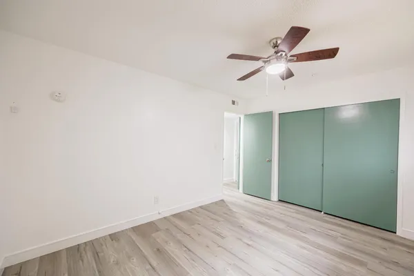 a view of empty room with wooden floor
