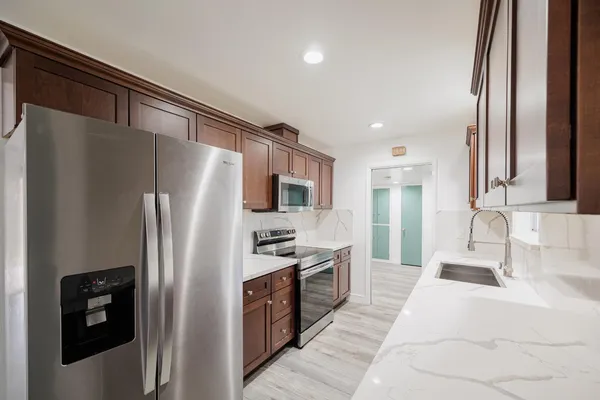 a kitchen with stainless steel appliances granite countertop a refrigerator and a sink