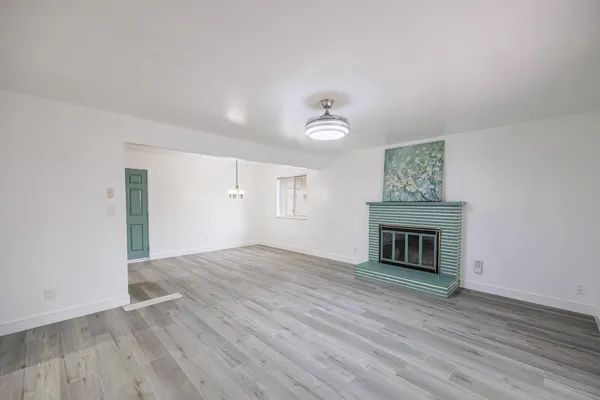 a view of empty room with wooden floor and fireplace