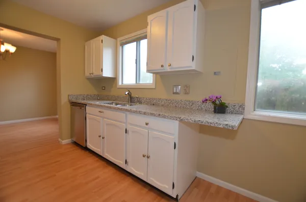 a kitchen with granite countertop white cabinets and white appliances