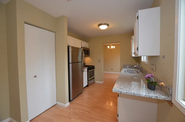 a kitchen with granite countertop kitchen island stainless steel appliances a refrigerator sink stove and granite counter top