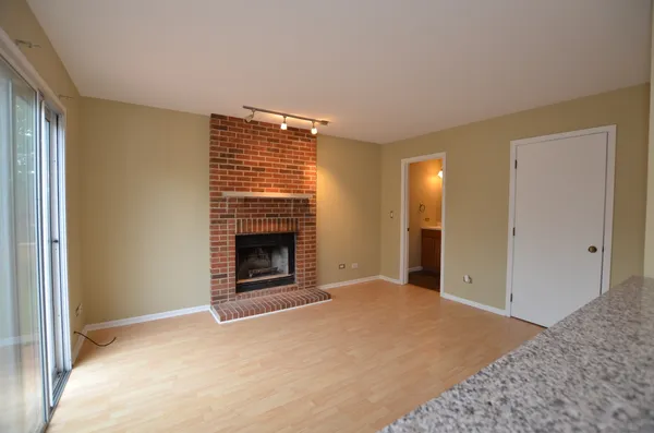 a view of an empty room with a fireplace and a window