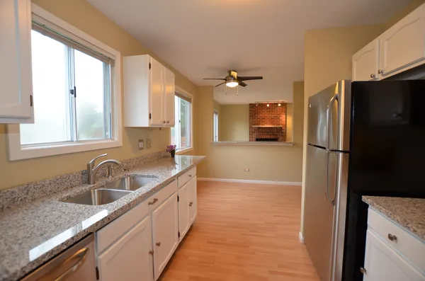 a kitchen with a refrigerator sink and cabinets