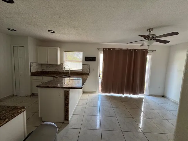 a kitchen with kitchen island granite countertop a refrigerator oven a sink and dishwasher