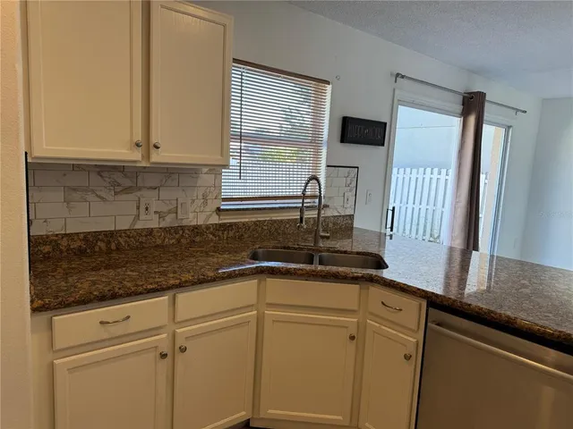 a kitchen with stainless steel appliances granite countertop cabinets sink and window