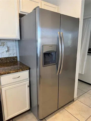 a close view of a refrigerator in kitchen and stainless steel appliances wooden floor