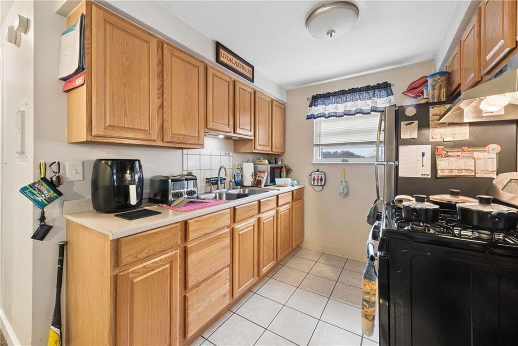 403 Homewood Avenue Trafford, PA 15085 - Photo 13 of 30 a kitchen with stainless steel appliances granite countertop a sink stove and refrigerator
