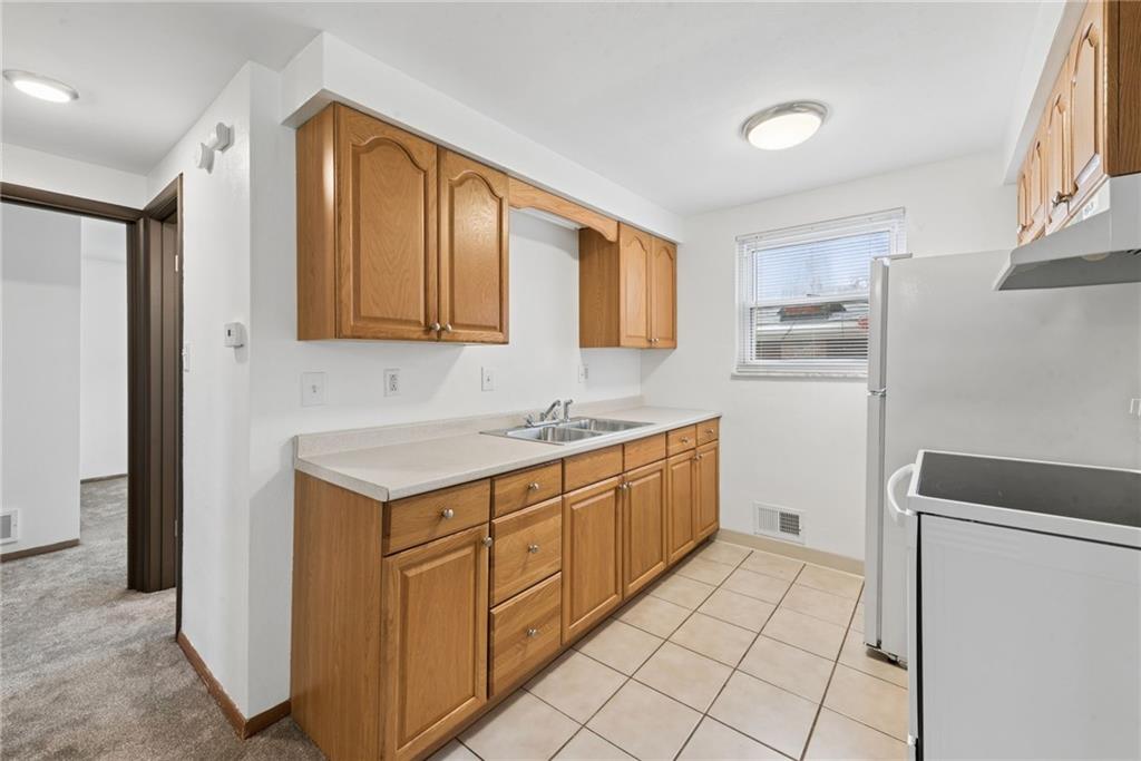 403 Homewood Avenue Trafford, PA 15085 - Photo 6 of 30 a kitchen with granite countertop a sink stove and cabinets