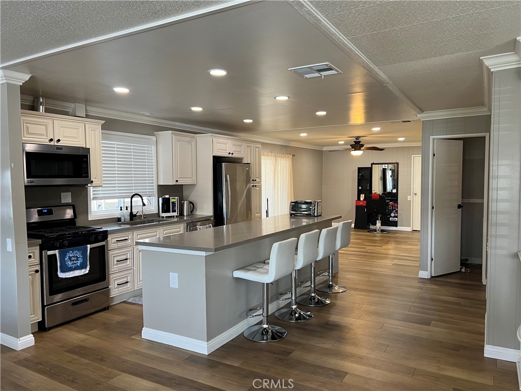 a large white kitchen with lots of counter space a sink and appliances