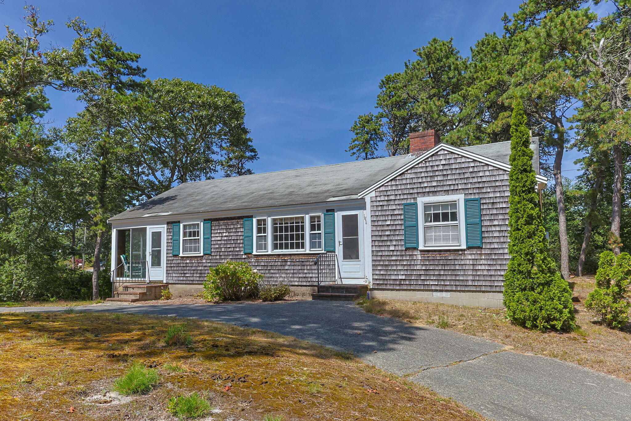 a front view of a house with a yard and potted plants
