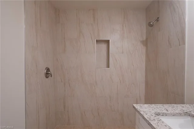 a bathroom with a granite countertop sink and white cabinets