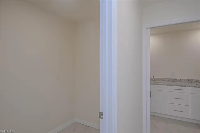 an empty room with closet and a hallway